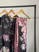 Floral-patterned scarves on a rack against a plain background