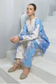 Woman sitting on stairs wearing a blue and white floral outfit with a white background