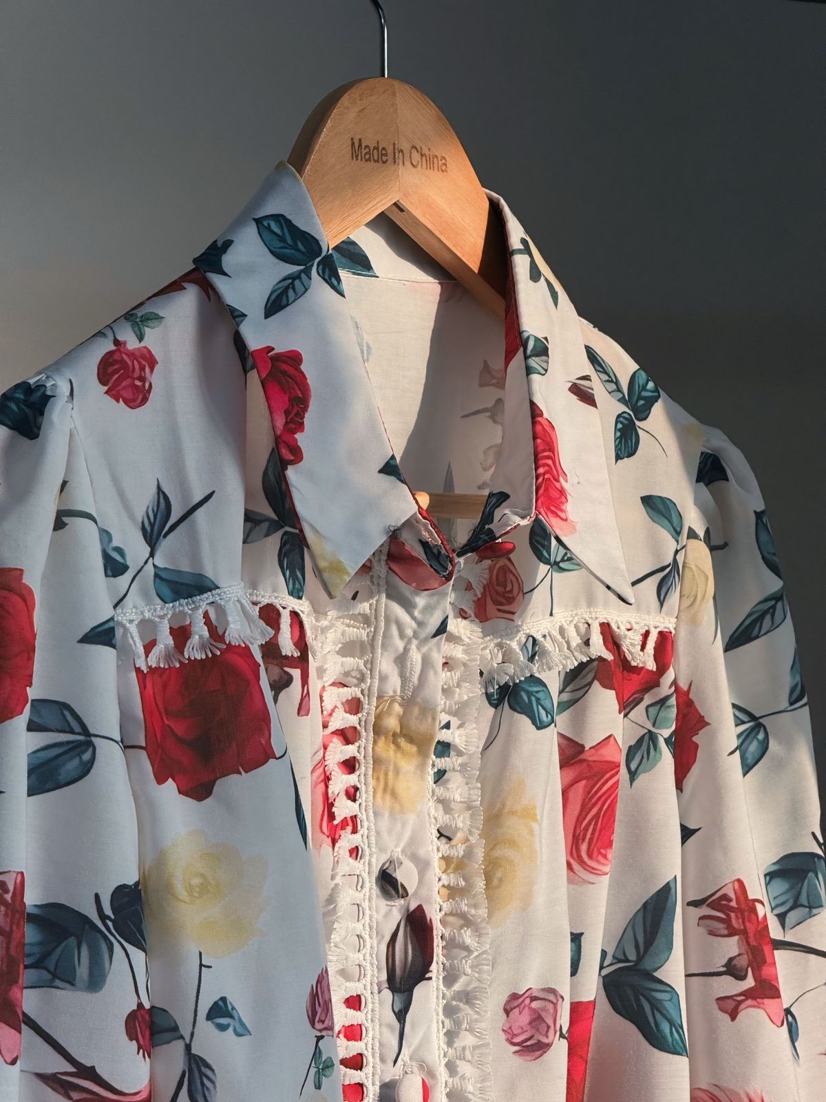 Floral patterned shirt on a hanger with 'Made in China' label.