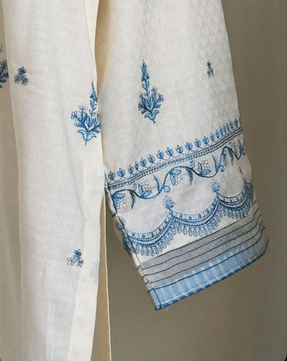 White fabric with blue embroidery on a beige background