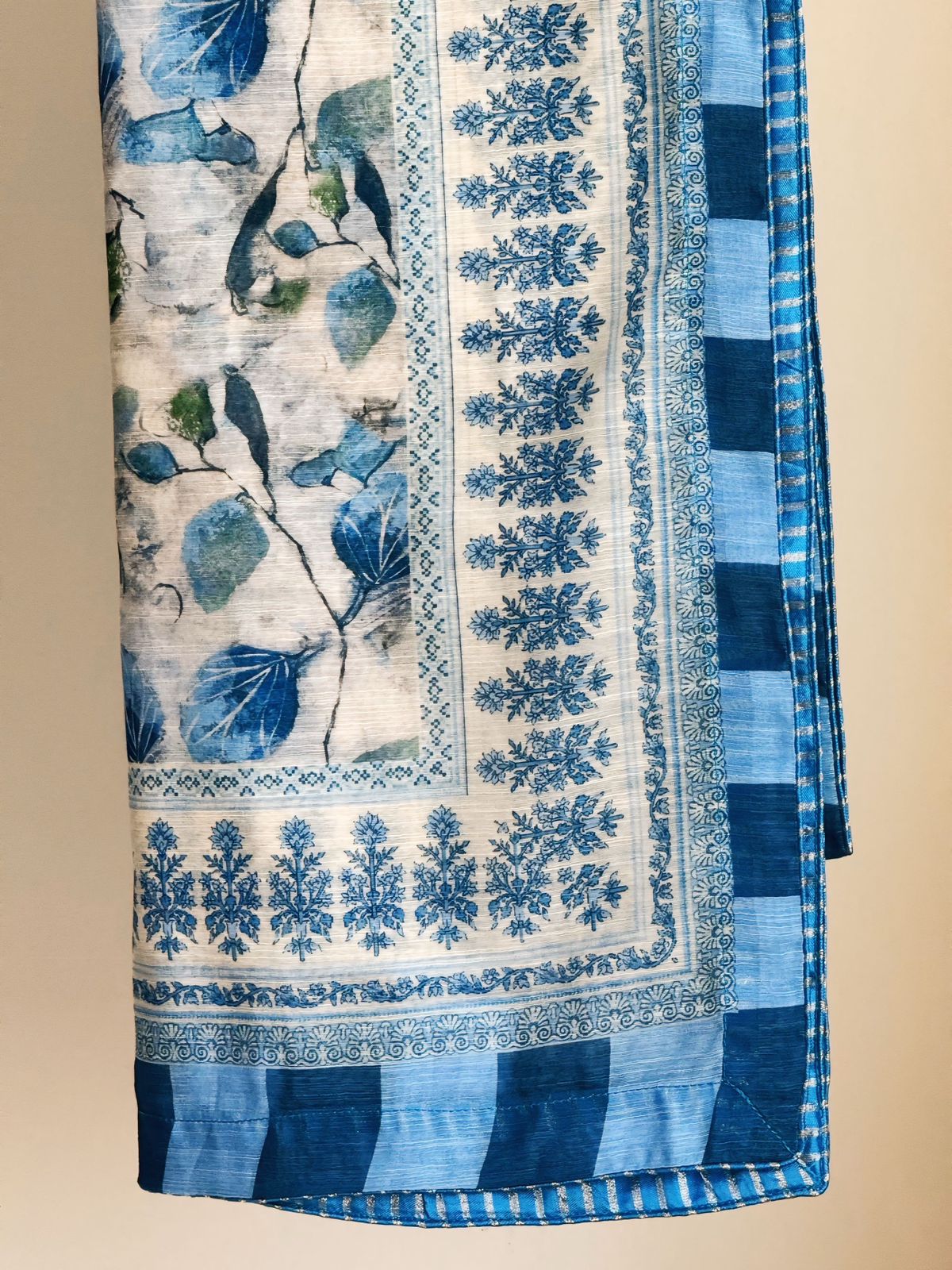 Blue and white patterned fabric with floral designs on a beige background