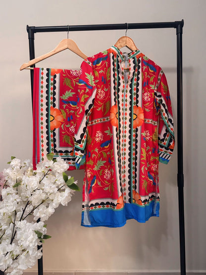 Colorful embroidered garment on a rack with white flowers in the foreground