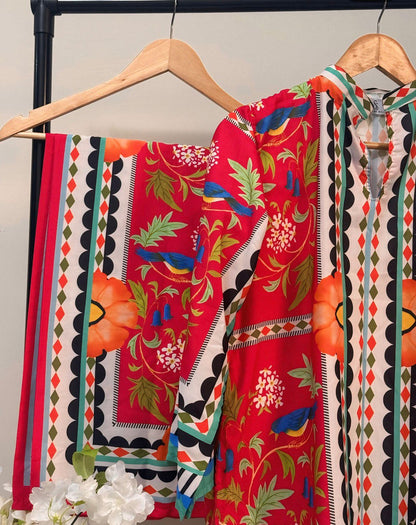 Colorful patterned fabric on a hanger with a floral arrangement in the foreground.